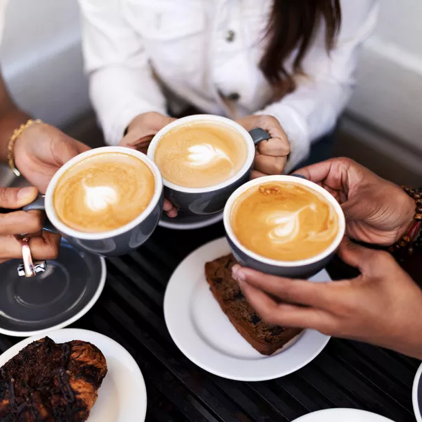3 people toast with 3 cups of coffee