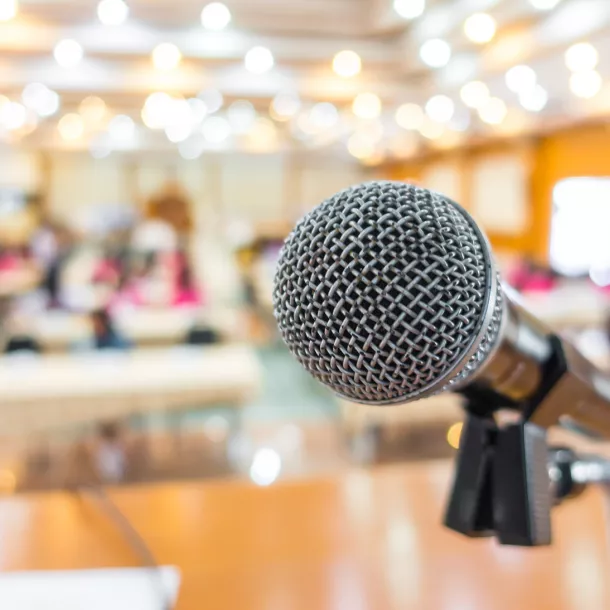 Microphone in front of a full hall.