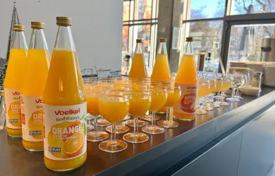 Orangensaft Flaschen und damit gefüllte Gläser.