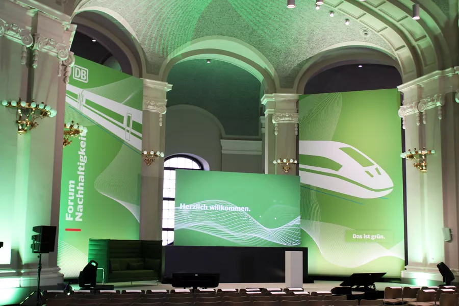 Large hall with green lighting and green screens with ICEs on them.